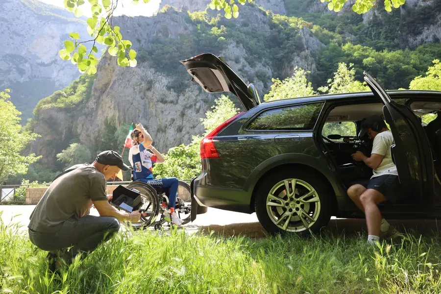 On set of Breaking Barriers: the crew beside the car on a mountain road, unloading the handbike