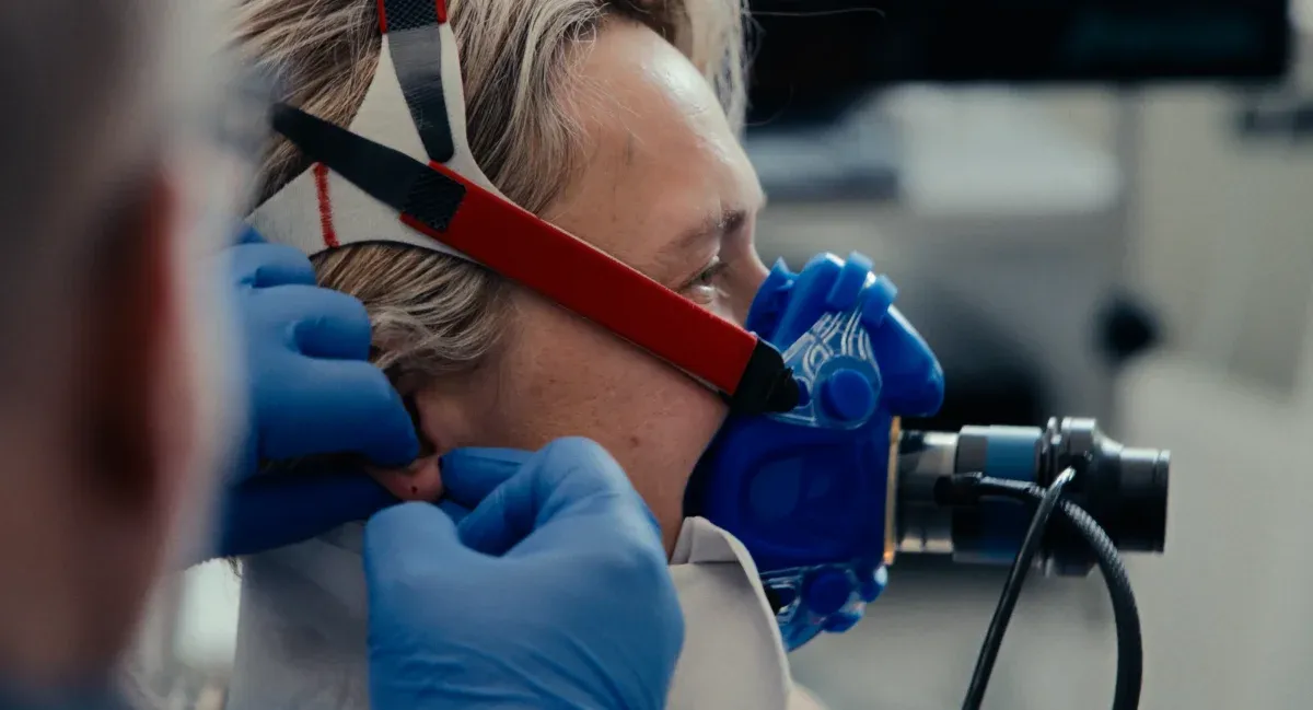 Film still from Breaking Barriers: a breathing mask being fitted during a performance test